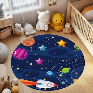 May include: A round, navy blue rug with a space theme. The rug features planets, stars, and a rocket ship design. The planets are purple, orange, and green, and the stars are gold and blue. The rocket ship is white and red.