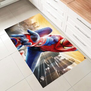 Pu&ograve; includere: Un tappeto rettangolare con un'immagine vibrante di Spider-Man in una posa dinamica. Il tappeto mostra il costume rosso e blu di Spider-Man, con uno sfondo di citt&agrave; e un cielo giallo e arancione.