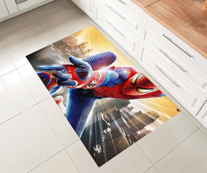 Pu&ograve; includere: Un tappeto rettangolare con un'immagine vibrante di Spider-Man in una posa dinamica. Il tappeto mostra il costume rosso e blu di Spider-Man, con uno sfondo di citt&agrave; e un cielo giallo e arancione.