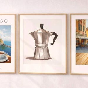 Pode incluir: Três impressões de arte emolduradas com temas de café. A impressão da esquerda diz "ESPRESSO" e mostra uma cena costeira com uma xícara de café. A impressão do meio apresenta uma cafeteira italiana prateada. A impressão da direita retrata uma cena de rua com uma xícara de café.