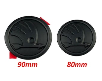 May include: Two black circular car emblems, one 90mm and the other 80mm in diameter, are displayed against a white background. Each emblem features a stylized design with an arrow. The text "90mm" and "80mm" are printed in red.