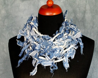 May include: A blue denim scarf with frayed edges, displayed on a black mannequin.