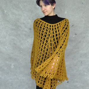 Peut inclure: Un haut en crochet jaune moutarde avec un design ample et ajour&eacute; et des manches bouffantes. Le haut a une coupe l&eacute;g&egrave;rement &eacute;court&eacute;e et une coupe ample.