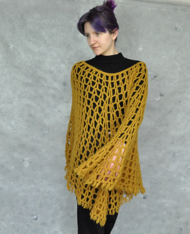 Peut inclure: Un haut en crochet jaune moutarde avec un design ample et ajour&eacute; et des manches bouffantes. Le haut a une coupe l&eacute;g&egrave;rement &eacute;court&eacute;e et une coupe ample.