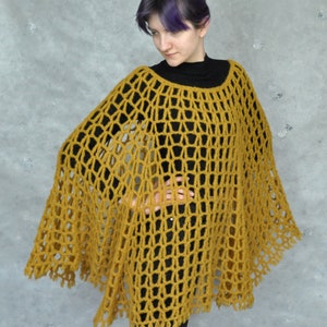 Peut inclure: Un poncho en crochet jaune moutarde &agrave; maille l&acirc;che et ouverte, avec une bordure en franges.