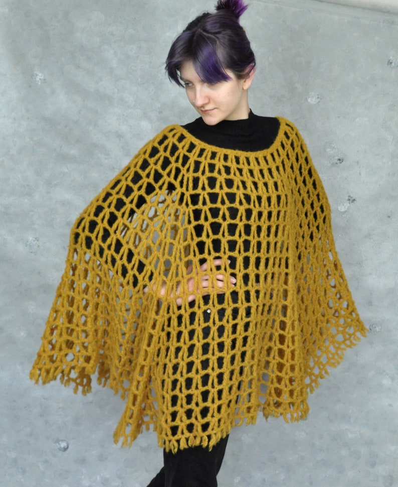 Peut inclure: Un poncho en crochet jaune moutarde &agrave; maille l&acirc;che et ouverte, avec une bordure en franges.
