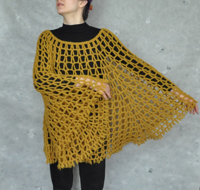 Peut inclure: Un poncho en crochet jaune moutarde &agrave; la maille l&acirc;che et ouverte, avec une silhouette ample et fluide.