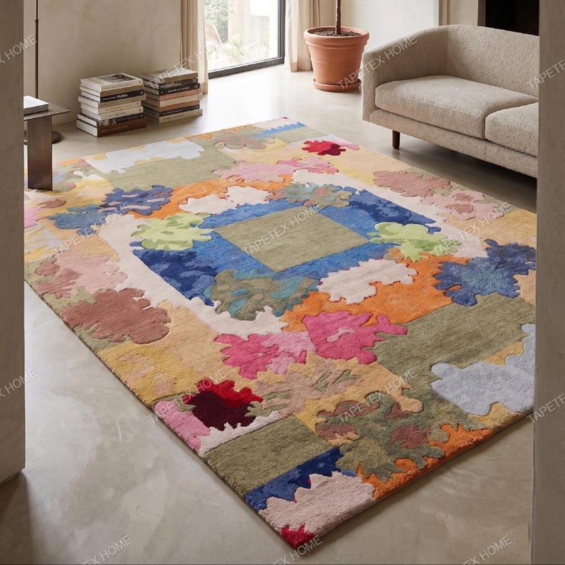 Puede incluir: Una alfombra grande y colorida con un dise&ntilde;o de patchwork. La alfombra presenta una variedad de colores, incluyendo azul, naranja, rosa y verde, en un patr&oacute;n floral o abstracto. La alfombra es rectangular y parece estar hecha de un material suave.