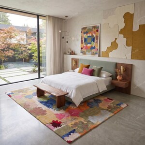 Puede incluir: Dormitorio moderno con cama, cabecero verde, cojines coloridos y alfombra estampada. Un banco de madera al pie de la cama. Ventanas grandes y pintura abstracta colorida. Dise&ntilde;o de interiores.