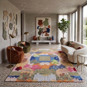 Puede incluir: Una colorida alfombra abstracta con un dise&ntilde;o geom&eacute;trico. La alfombra presenta una mezcla de colores pastel, incluyendo rosa, azul, naranja y verde. Se encuentra en un sal&oacute;n moderno con un sof&aacute; blanco y dos sillones.