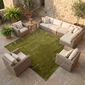 May include: Outdoor patio furniture set with a large green rug. The set includes a sectional sofa, two armchairs, and a small wooden table. The furniture has woven wicker frames and beige cushions.