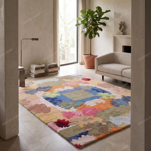 Puede incluir: Una colorida alfombra con un dise&ntilde;o geom&eacute;trico. La alfombra presenta un cuadrado central azul, rodeado por un mosaico de varios colores, incluyendo rosa, naranja, verde y amarillo. Se encuentra en un sal&oacute;n.