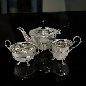 Peut inclure: Ensemble de trois mugs en céramique avec une finition mate et mouchetée. Les mugs sont de couleur crème, gris clair et gris foncé. Chaque mug a un design simple et minimaliste, idéal pour le café ou le thé.