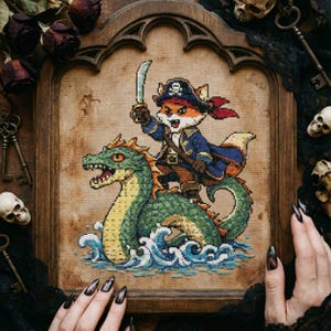 Può includere: Arte a punto croce di una volpe pirata con una spada che cavalca un serpente marino verde. La volpe indossa un cappotto blu e un cappello da pirata. L'opera è incorniciata in una cornice gotica di legno, con un'estetica vintage.