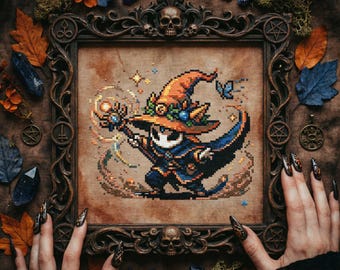 May include: Cross-stitch art of a wizard in an orange hat and blue cloak, framed in a dark wood frame with skull and pentagram details. The artwork is surrounded by autumn leaves, crystals, and moss.