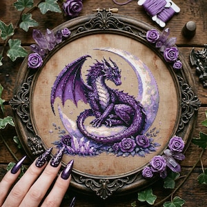 May include: A framed cross-stitch featuring a purple dragon perched on a crescent moon. The dragon has detailed wings and scales. The frame is adorned with purple roses and crystals. The color palette includes shades of purple and brown.