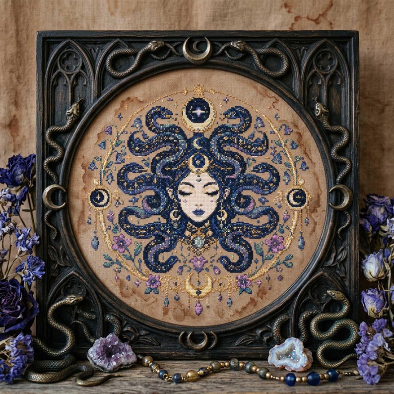 This celestial Medusa cross stitch pattern features a mystical serpent goddess surrounded by flowing cosmic snakes, golden moon symbols, celestial ornaments, and delicate floral accents. Inspired by mythology and dark fantasy aesthetics, the design transforms Medusa into a peaceful moonlit queen filled with elegance and magical energy. Deep navy blue tones blend with soft lavender, dusty pink, and gold celestial details to create an enchanting embroidery composition perfect for gothic home décor