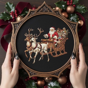 Könnte beinhalten: Kreuzstich-Stickerei von Santa Claus in einem von Rentieren gezogenen Schlitten, in einem dekorativen Holzrahmen. Das Kunstwerk zeigt Santa in einem roten Anzug, einen mit Geschenken gefüllten Schlitten und Rentiere mit detaillierten Stichen. Der Rahmen ist dunkelbraun.