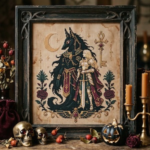 May include: A framed cross-stitch embroidery on beige fabric featuring a black jackal-headed figure and a blonde knight in armor holding a sword. The design includes a crescent moon, an ornate key, and roses, all enclosed in a dark wooden frame.