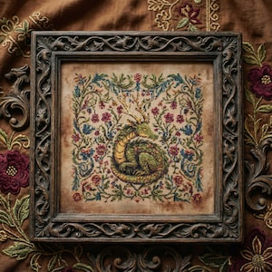 以下が含まれることがあります： 緑と黄色のドラゴンが中央に描かれた額入りのクロスステッチ。赤、青、緑の花柄のボーダーで囲まれています。フレームは、装飾的な彫刻が施された濃い茶色です。