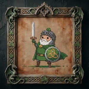 May include: Cross-stitch artwork of a cartoon knight in green armor, holding a sword and shield with a Celtic knot design. The artwork is framed in a wooden frame with dragon and shamrock embellishments.