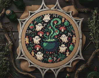 May include: A cross-stitch embroidery featuring a witchy theme. The design includes a cauldron, ghosts, mushrooms, and potion bottles in a circular frame. The color palette is dark with green, red, and white accents. The frame is a light gray color.