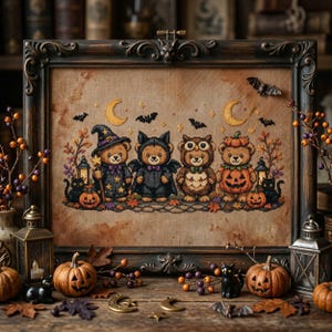 May include: A framed cross-stitch embroidery on tan fabric featuring four teddy bears in Halloween costumes: a witch, a bat, an owl, and a pumpkin. The scene includes two yellow crescent moons, black bats, lanterns, and black cats.