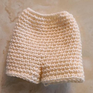 May include: White crocheted shorts with a textured pattern.