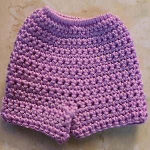 May include: Purple crocheted shorts with a textured pattern.