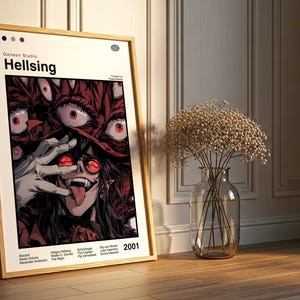 May include: A framed poster for the anime series "Hellsing." The artwork depicts a character with red eyes and a long tongue, surrounded by other red eyes. The poster is in a wooden frame and is leaning against a wall.
