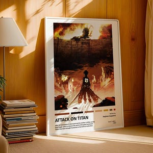 Op de afbeelding: Een ingelijste Attack on Titan-poster. Het kunstwerk toont een silhouet op de voorgrond, met een brandende stad en een gigantische figuur op de achtergrond. De poster bevat de titel "ATTACK ON TITAN" en tekst eronder. De lijst is wit.