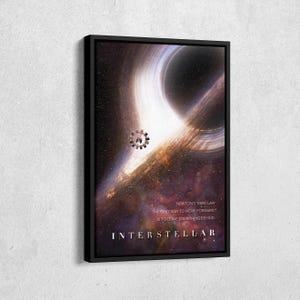 May include: A framed art print depicting a black hole and a galaxy. The print has the text "NEWTON'S THIRD LAW THE ONLY WAY TO MOVE FORWARD IS TO LEAVE SOMETHING BEHIND" and the title "INTERSTELLAR".