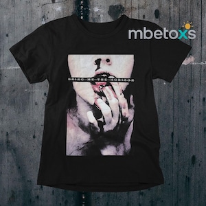 以下が含まれることがあります： 顔と口の近くにある指のグラフィックが特徴の黒いTシャツ。テキスト「BRING ME THE HORIZON」が画像に印刷されています。シャツは柔らかい素材で作られています。