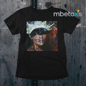 Puede incluir: Camiseta negra con un gráfico de una persona con una corona y la palabra "PURPOSE" en blanco. La imagen también incluye el texto "BELIEVE IN YOU". La camiseta es de cuello redondo.