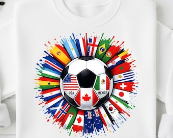 Könnte beinhalten: Weißes Sweatshirt mit einem Fußball-Design, das Flaggen verschiedener Länder zeigt. Der Fußball zeigt die Flaggen der USA, Kanadas und Mexikos. Das Design umfasst farbenfrohe Farbspritzer und Flaggen aus aller Welt.