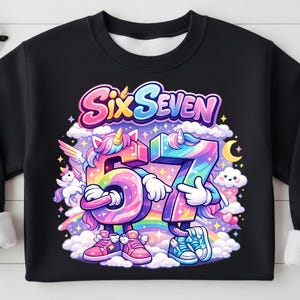 May include: Black sweatshirt with a colorful graphic featuring the words "Six Seven" above the numbers 6 and 7, designed as cartoon unicorns. The numbers are rainbow-colored, with clouds, a rainbow, and a crescent moon.