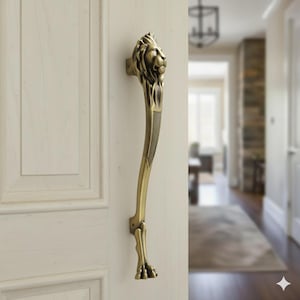 以下が含まれることがあります： 上部にライオンの頭、下部にライオンの足が付いたブロンズ色のドアハンドル。ハンドルは白いドアに取り付けられています。ハンドルにはテクスチャード加工されたグリップが付いています。