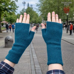 Op de afbeelding: Turquoise vingerloze handschoenen, gehaakt met een geribbelde textuur. De handschoenen bedekken de hand tot aan de knokkels en lopen door tot de onderarm. De afbeelding bevat de tekst "Crochet pattern PDF".