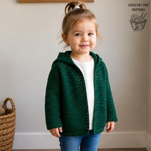 May include: A dark green hooded crochet cardigan worn over a white shirt and blue jeans. The image includes text in the upper right corner that reads CROCHET PDF PATTERN with a graphic illustration of a basket containing yarn and knitting needles.