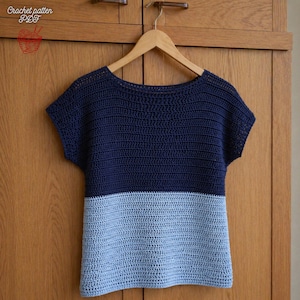 Può includere: Top all'uncinetto bicolore, blu navy e azzurro. La parte superiore a maniche corte è appesa a un'appendiabiti di legno. Il testo "Crochet pattern PDF" è visibile nell'angolo in alto a sinistra. Articolo fatto a mano.