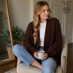 May include: A dark brown chunky knit cardigan with long sleeves and a ribbed trim, worn over a white shirt and light blue jeans. The image includes the text CROCHET PDF PATTERN and a graphic of a yarn basket with knitting needles in the corner.
