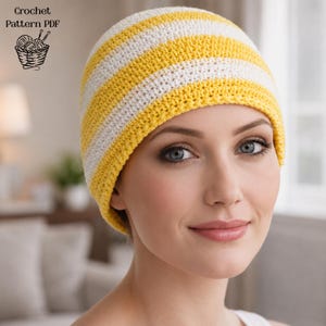 May include: A crocheted beanie in yellow and white stripes. The hat is handmade and appears soft. The image also includes the text "Crochet Pattern PDF" and a graphic of a basket with yarn and crochet hooks.