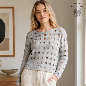 Könnte beinhalten: Ein hellgrauer Häkelpullover mit quadratischem Ausschnittmuster. Das langärmlige Oberteil hat einen Rundhalsausschnitt und wird mit hellfarbigen Hosen kombiniert. Das Bild enthält auch den Text "Crochet Pattern PDF" mit einem Korb aus Garn und Nadeln.