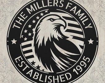 May include: A circular black metal wall sign featuring a stylized eagle head in the center. The design includes the text THE MILLERS FAMILY and ESTABLISHED 1995, along with a graphic of stars and stripes representing the American flag motif.