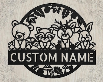 May include: A circular black metal wall sign featuring a cutout design of a bear, a raccoon, a deer, and a rabbit. The animals are positioned above a horizontal rectangular bar with the text CUSTOM NAME in a bold, sans-serif font.