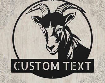 May include: A circular black metal wall sign featuring a detailed silhouette of a goat head with curved horns. Below the goat, a horizontal rectangular banner contains the words CUSTOM TEXT in a bold, stencil-style font, centered within the frame.