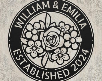 May include: A circular black metal wall sign featuring a cutout floral design in the center. The text WILLIAM & EMILIA is arched across the top, and the text ESTABLISHED 2024 is arched across the bottom within the circular border frame.