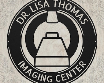 May include: A circular black metal sign featuring a stylized graphic of a medical imaging scanner in the center. The text DR. LISA THOMAS is arched across the top, and the words IMAGING CENTER are arched along the bottom of the circular frame.