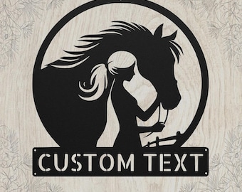 May include: A black metal wall art piece featuring a circular frame containing the silhouette of a horse and a person with a ponytail. Below the circle is a rectangular plaque with the cutout text CUSTOM TEXT in a bold, sans-serif font.