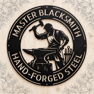 May include: A circular black metal wall sign featuring a silhouette of a blacksmith working at an anvil. The text "MASTER BLACKSMITH" is arched across the top, and "HAND-FORGED STEEL" is arched across the bottom of the circular frame.